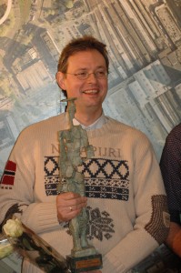 Peter J.R. Vermaat krijgt 1.000 euro mee naar huis en een beeldje van Lex Heilijgers. Foto aangeleverd door SLAU